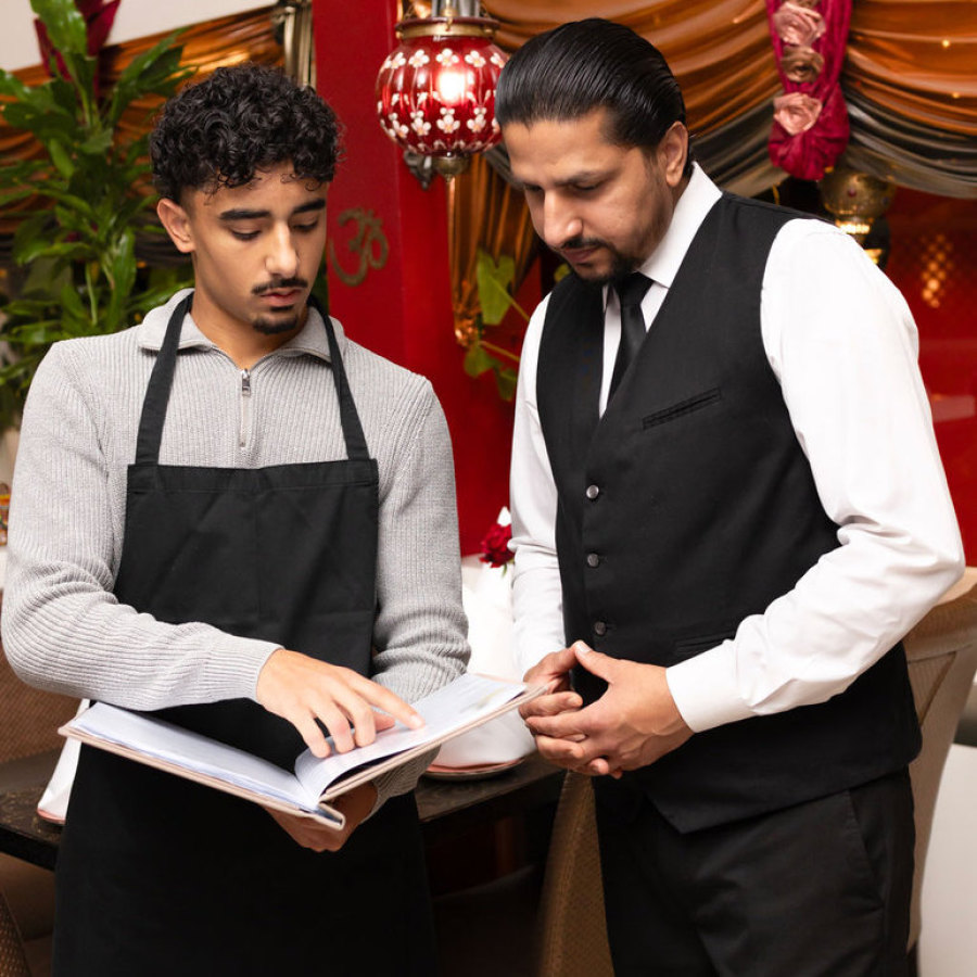 Service-Team des GURU Restaurants betrachtet die Speisekarte