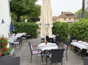 Gemütliche Terrasse des GURU Restaurants mit Tischen und Sonnenschirmen
